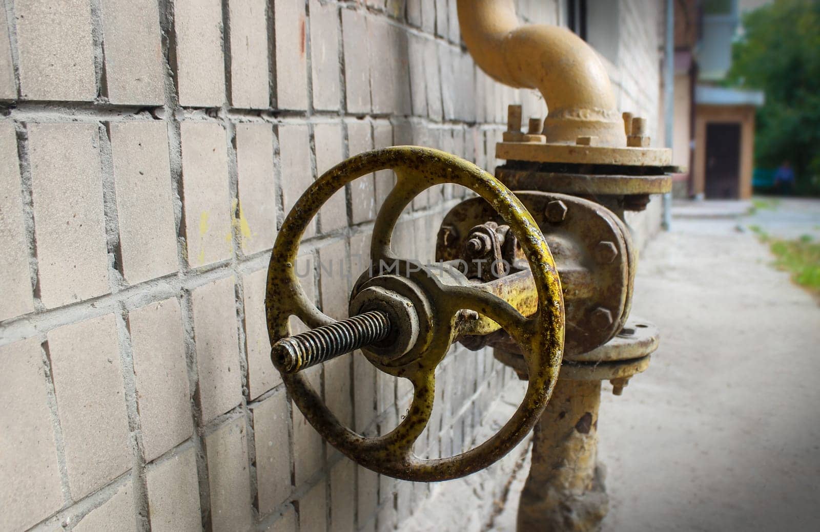 background of an old gas faucet on the background of the remnants of the tile and the bitumen surface