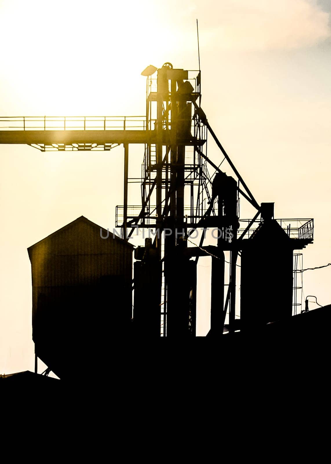 A Silhouette of a group of granaries for storing wheat and other cereal grains, located next to a railroad siding for easy loading and unloading.