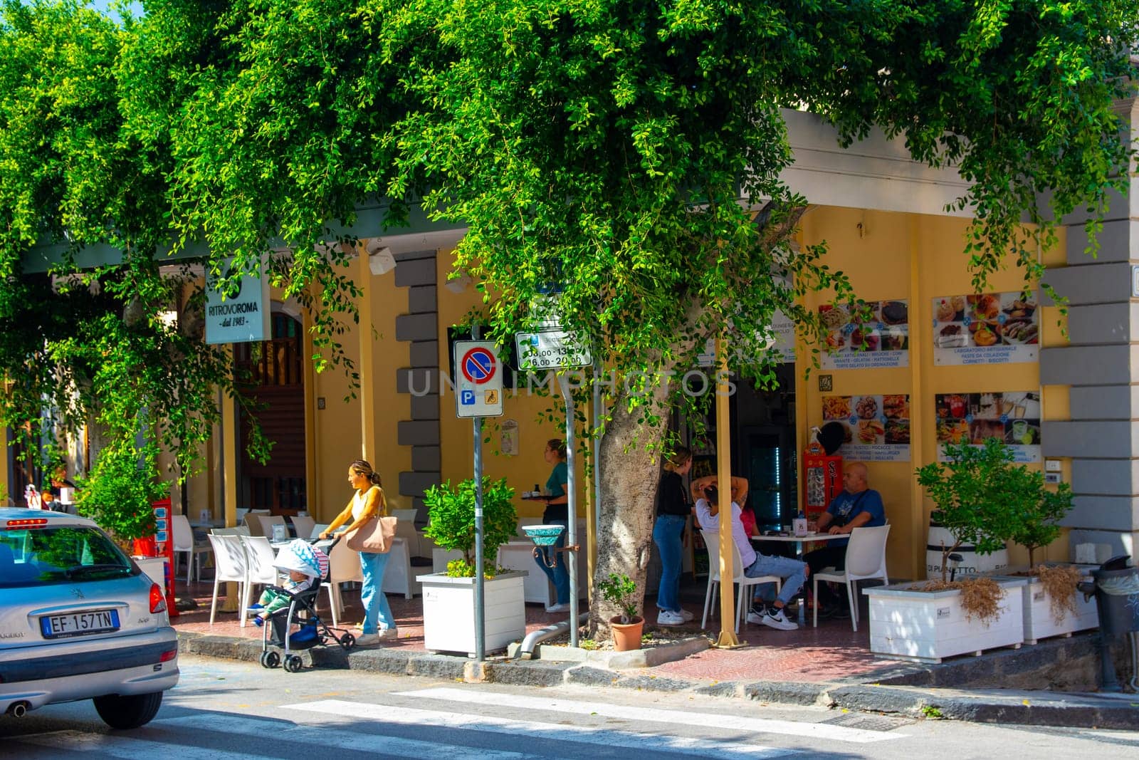 Gioiosa Marea, Sicily, Italy - 27. September 2023. Centre of the town of Gioiosa Marea with a street cafe and an ice cream bar in the province of Messina.