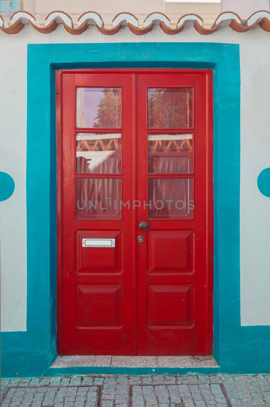 Tiny door painted with vivid colors at Vila Nova de Milfontes house. Little picturesque town on the Alentejo coast, Portugal