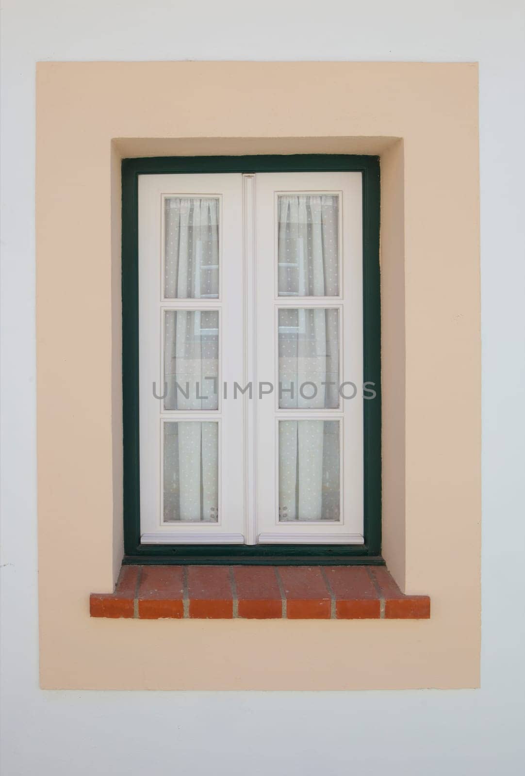 Tiny window painted with vivid colors at Vila Nova de Milfontes house. Little picturesque town on the Alentejo coast, Portugal