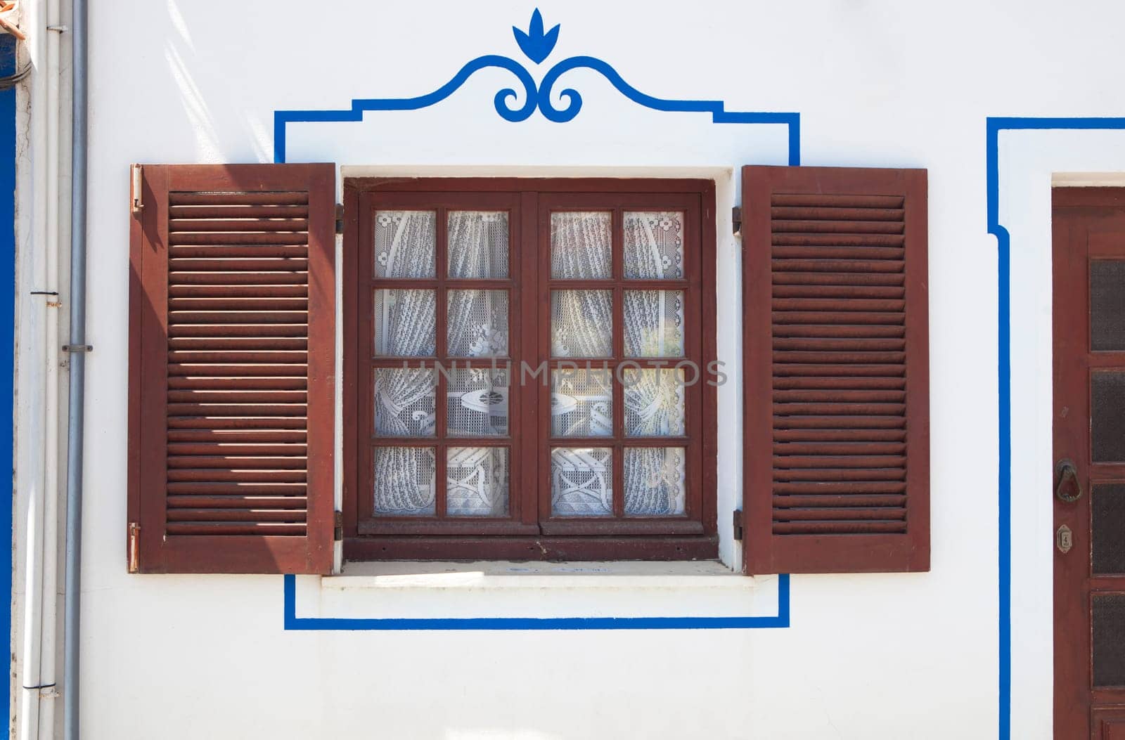 Tiny window painted with vivid colors at Vila Nova de Milfontes house. Little picturesque town on the Alentejo coast, Portugal