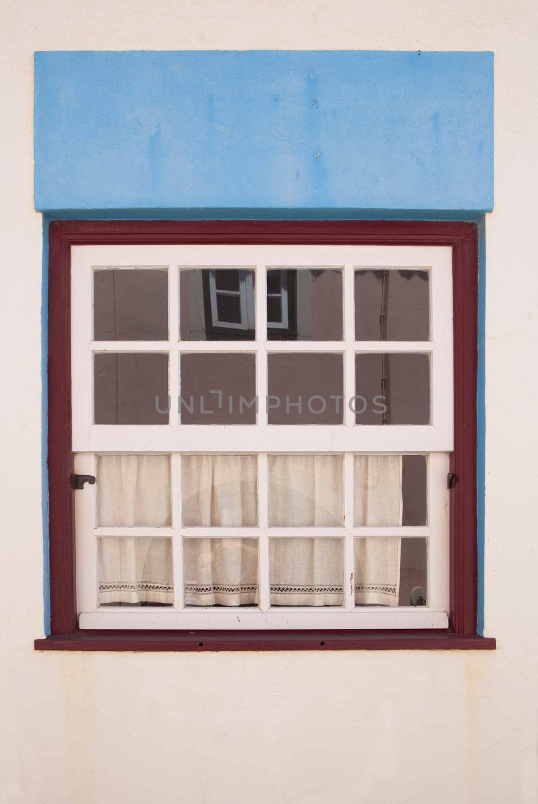 Tiny window painted with vivid colors at Vila Nova de Milfontes house. Little picturesque town on the Alentejo coast, Portugal