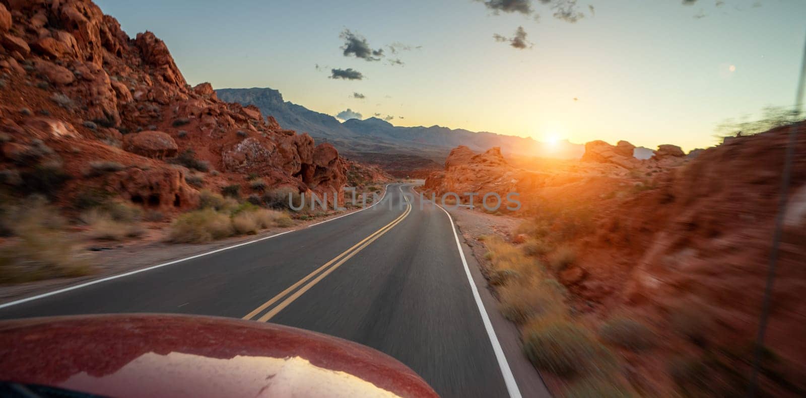 Empty long nevada mountain road to the horizon on a sunny summer day at bright sunset