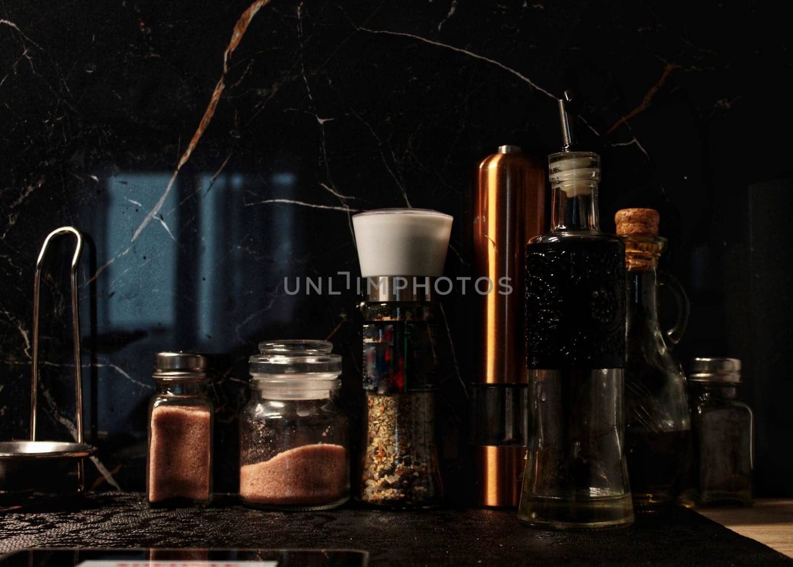 in the kitchen there are bottles with seasonings and cooking oil