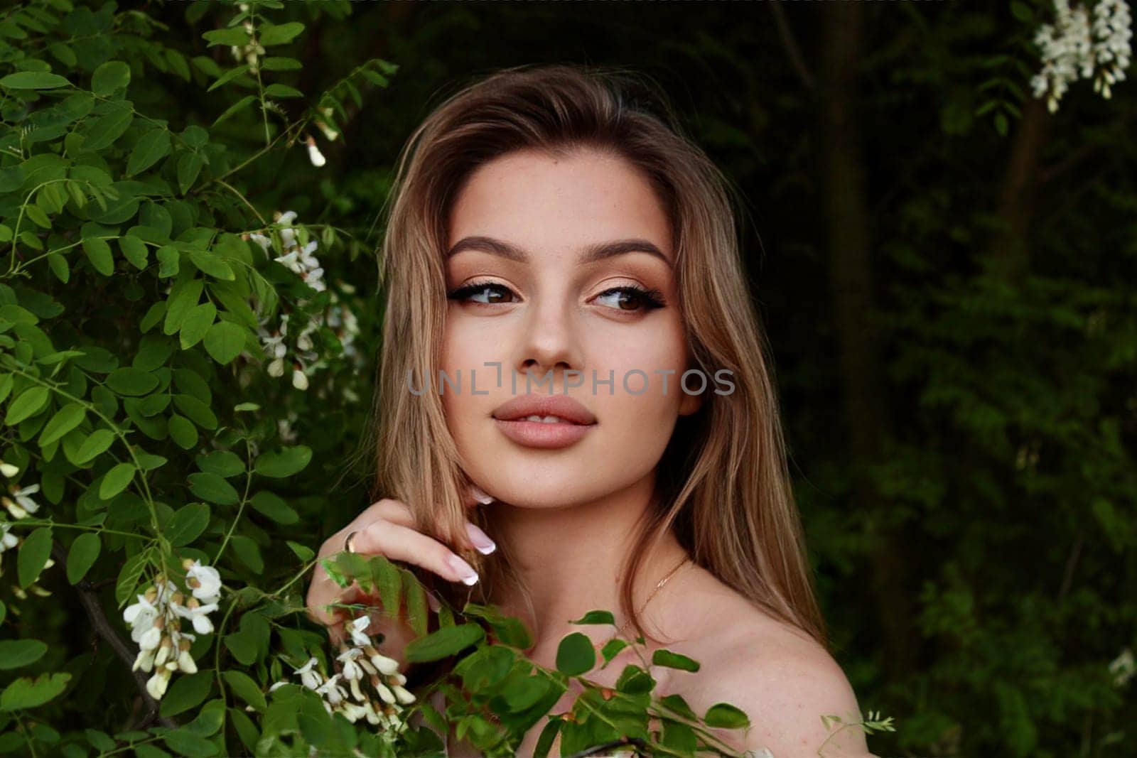 young beautiful woman taking a selfie in a field at sunset