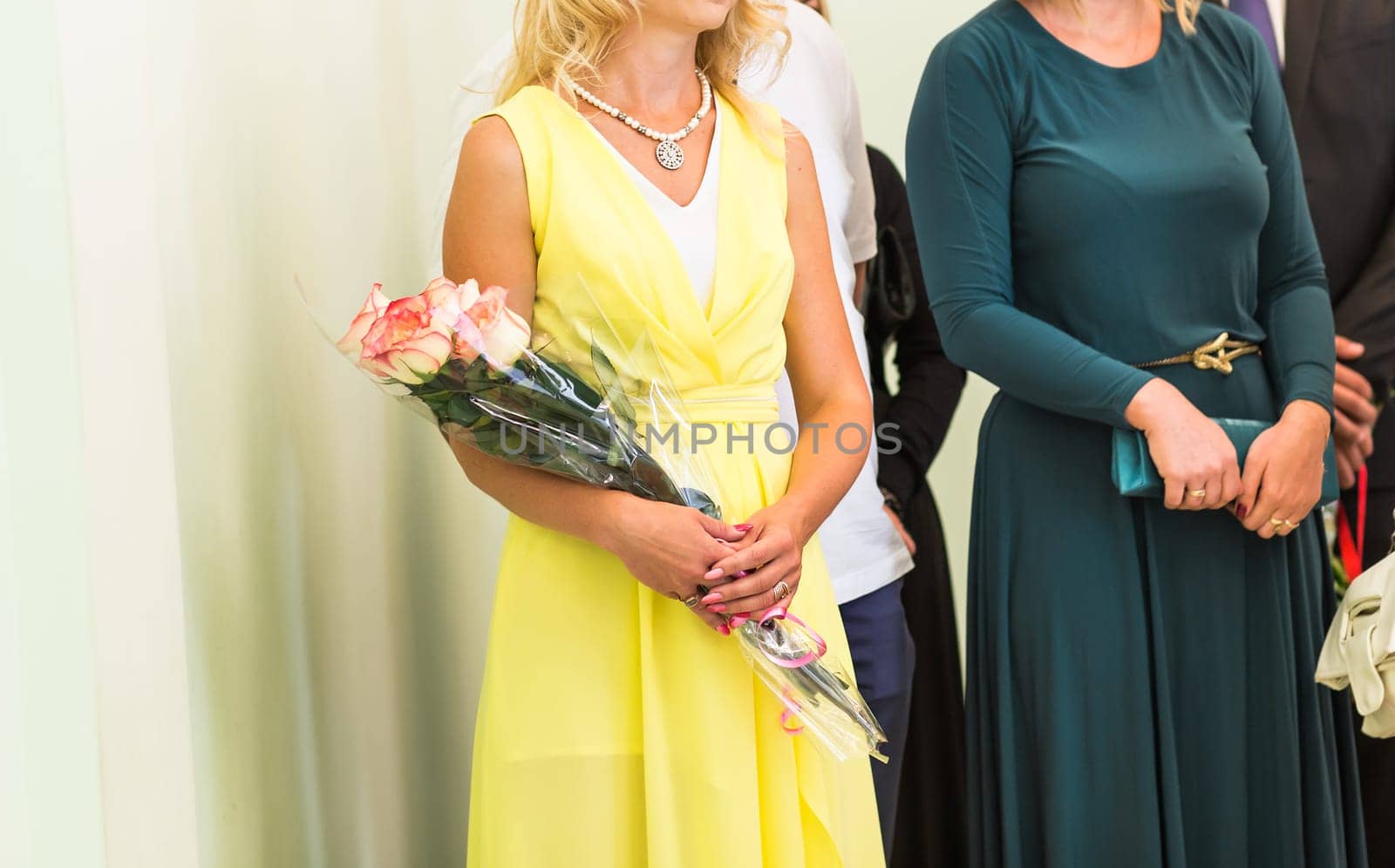Hands holding bouquet of beautiful pink roses.