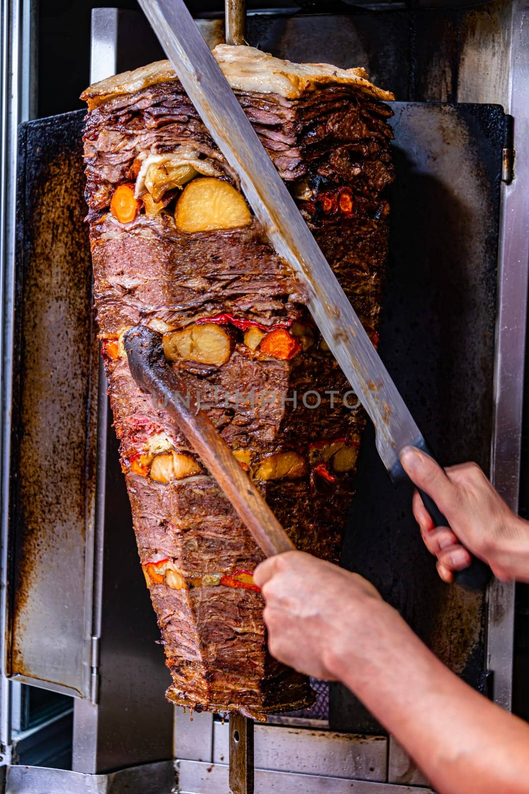 Traditional doner kebab roasted on vertical rotisserie in Turkish street restaurant