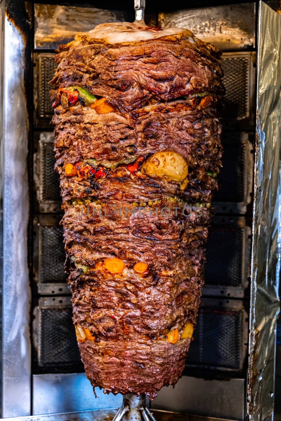 Traditional doner kebab roasted on vertical rotisserie in Turkish street restaurant