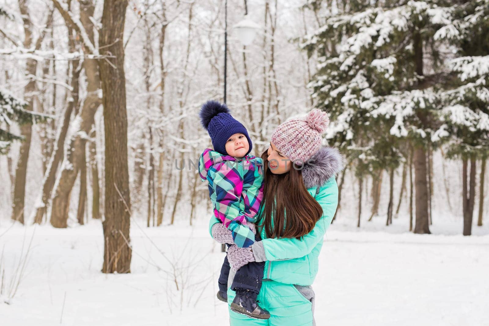 Portrait of happy mother and baby in winter park