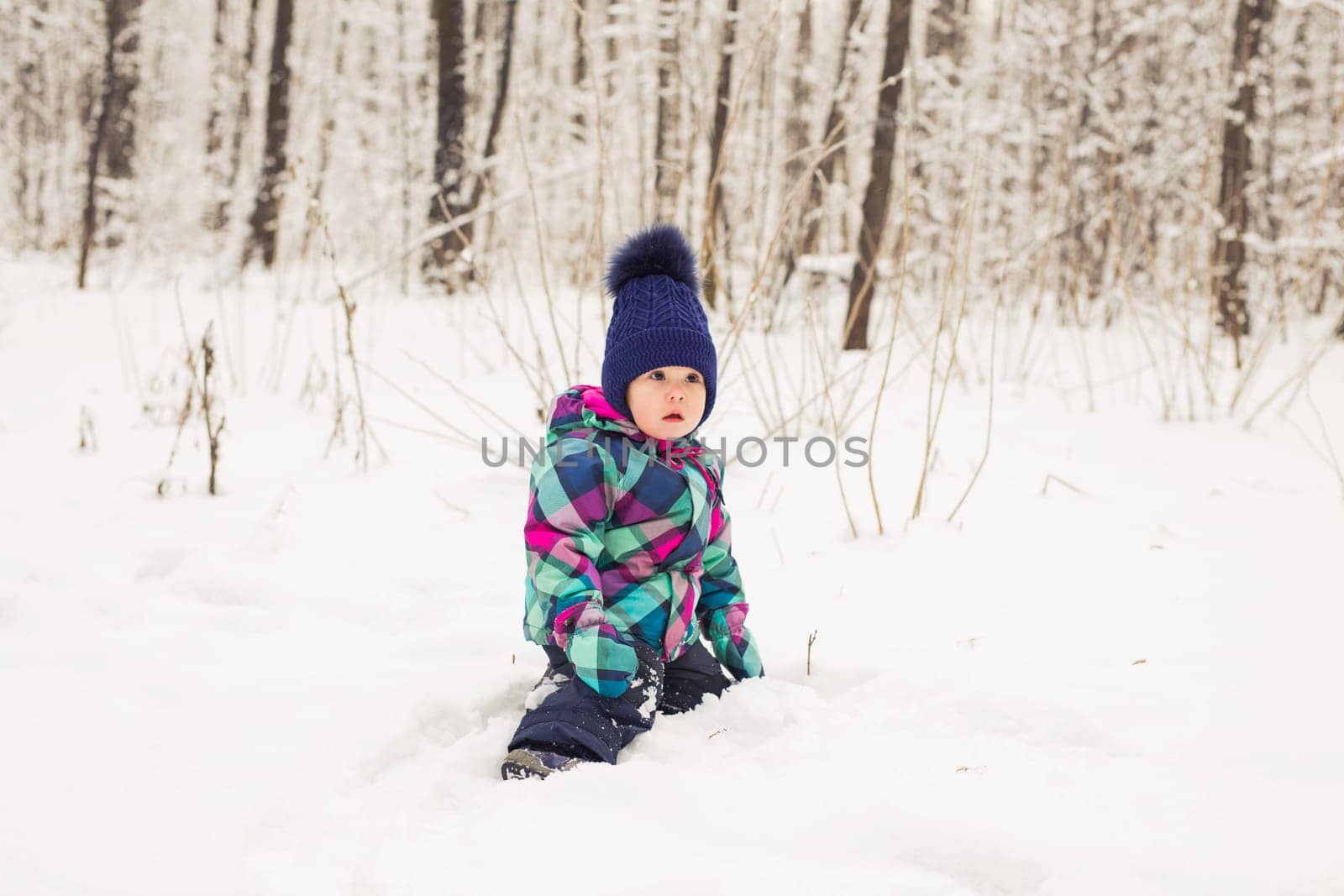 Happy little kid is playing in snow, good winter weather.