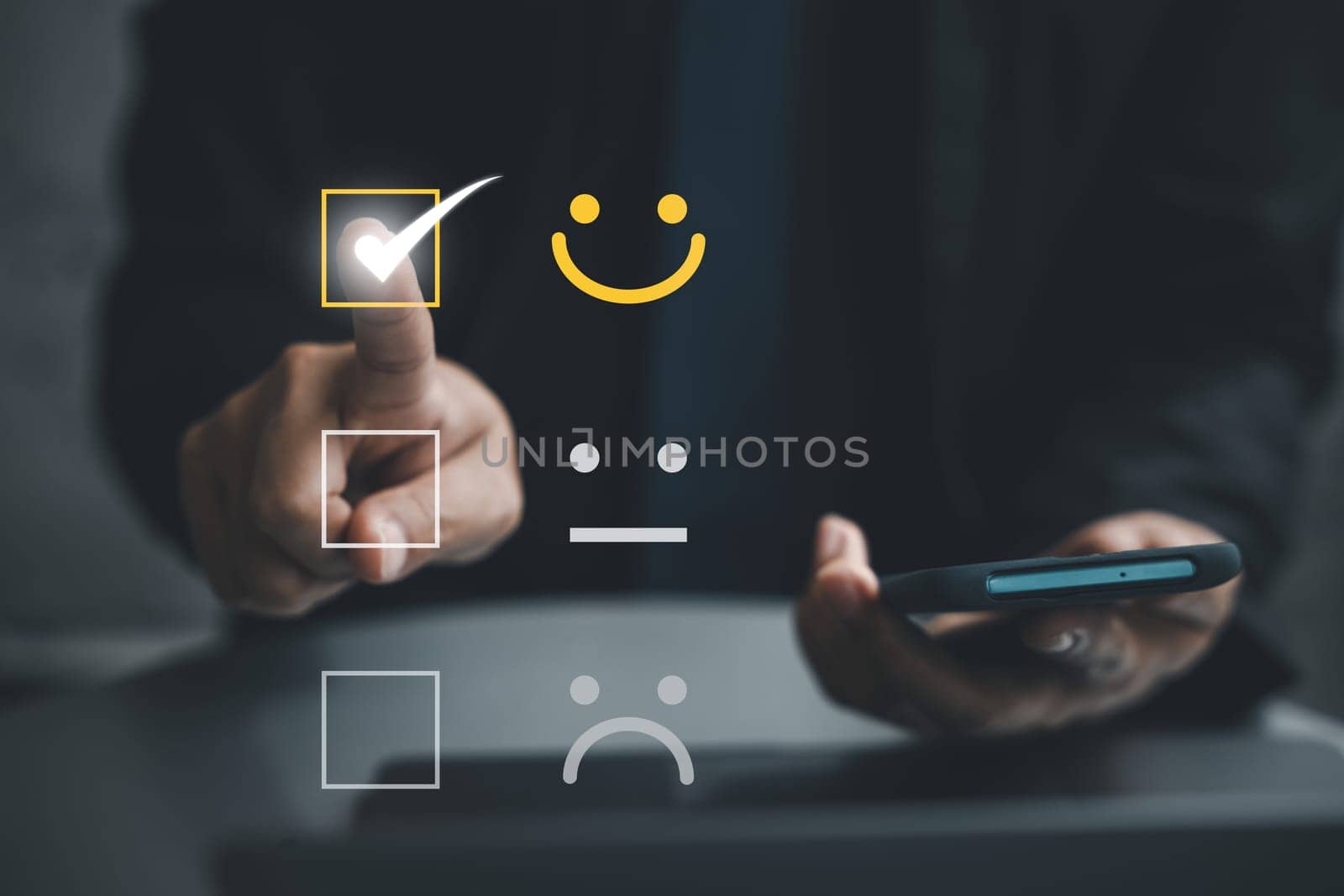 Close up of a man's hand using a smartphone and laptop computer to provide positive feedback for excellent service. Concept of business satisfaction survey and digital technology