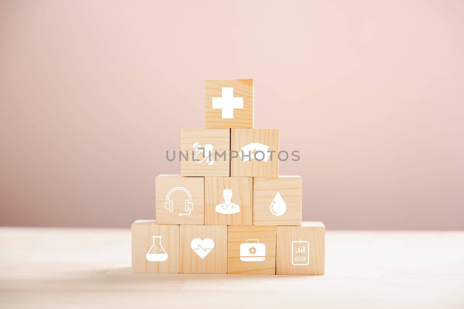 Pyramid of wooden cubes signifies healthcare and insurance. Topped with a medical insurance icon against white backdrop, leaving room for Health Insurance communication.