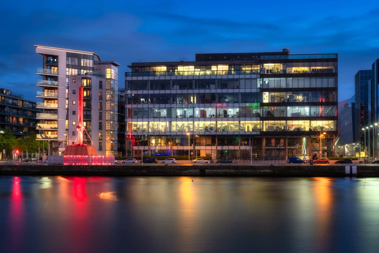 Dublin, Ireland, 10 Oct 2020 Iconic Diving Bell, modern offices and apartment buildings on Sir John Rogerson Quay and blurred Liffey River at dusk
