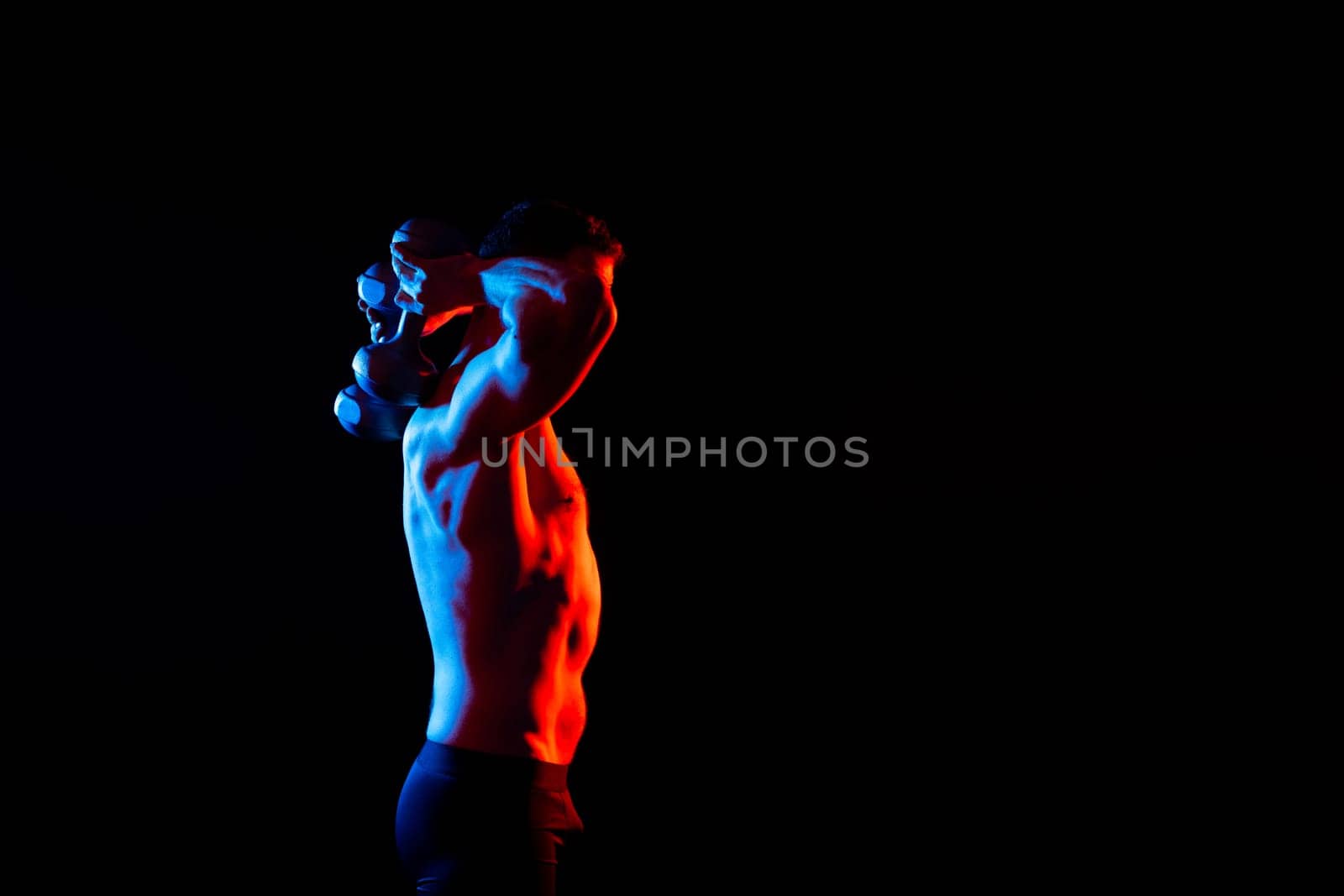 Handsome young fitness sporty strong guy bare-chested muscular sportsman on a studio background