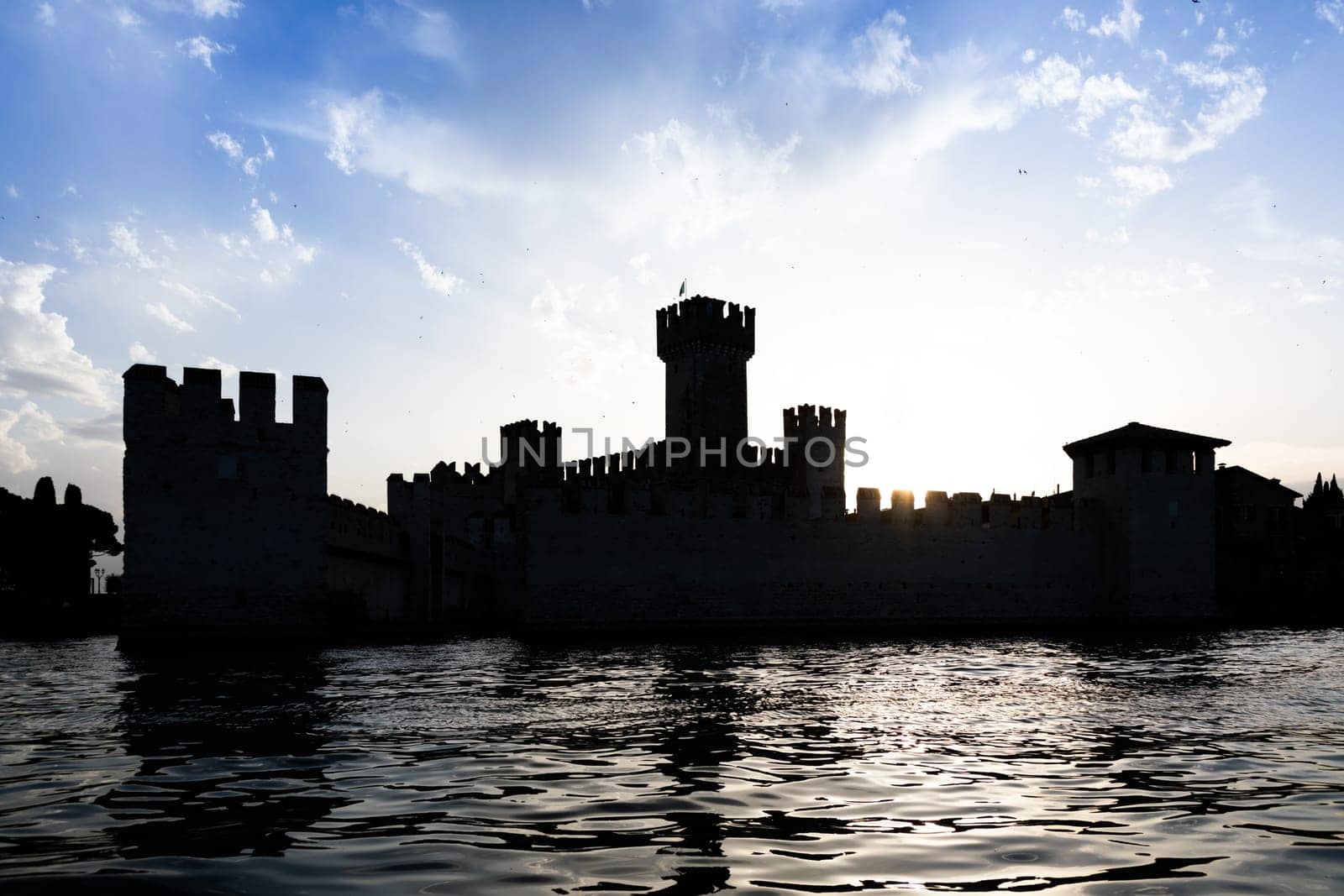 Italy - Sirmone castle silhouette on the Garda lake at sunset. Medieval architecture with tower