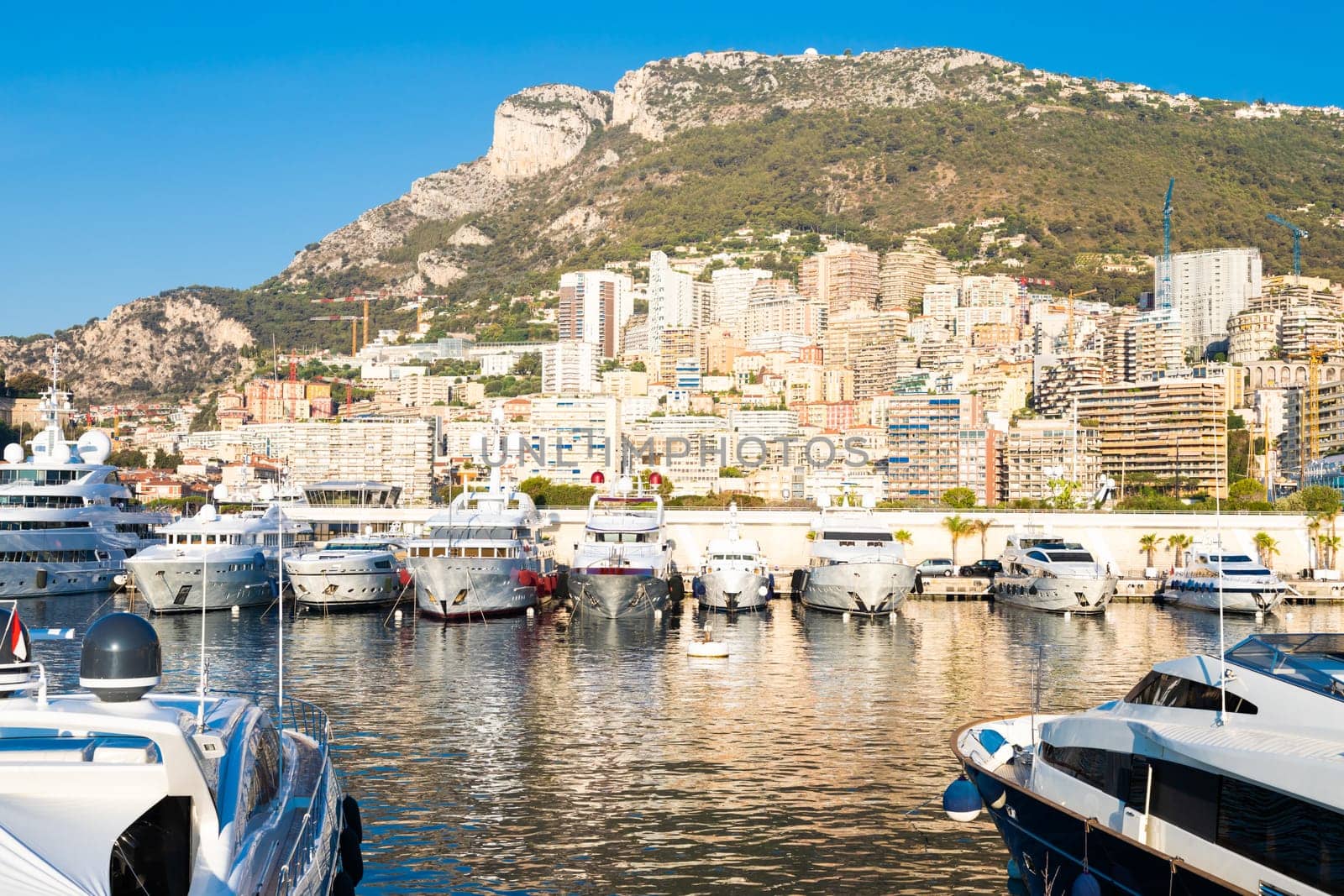Monte Carlo, Monaco - August 2022: Port Hercule with luxury yachts,  boats, and scenery skyline