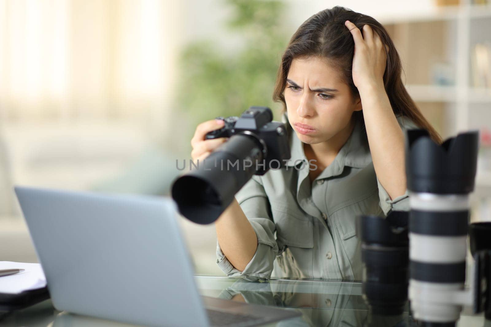 Worried photographer checking result on mirrorless camera at home