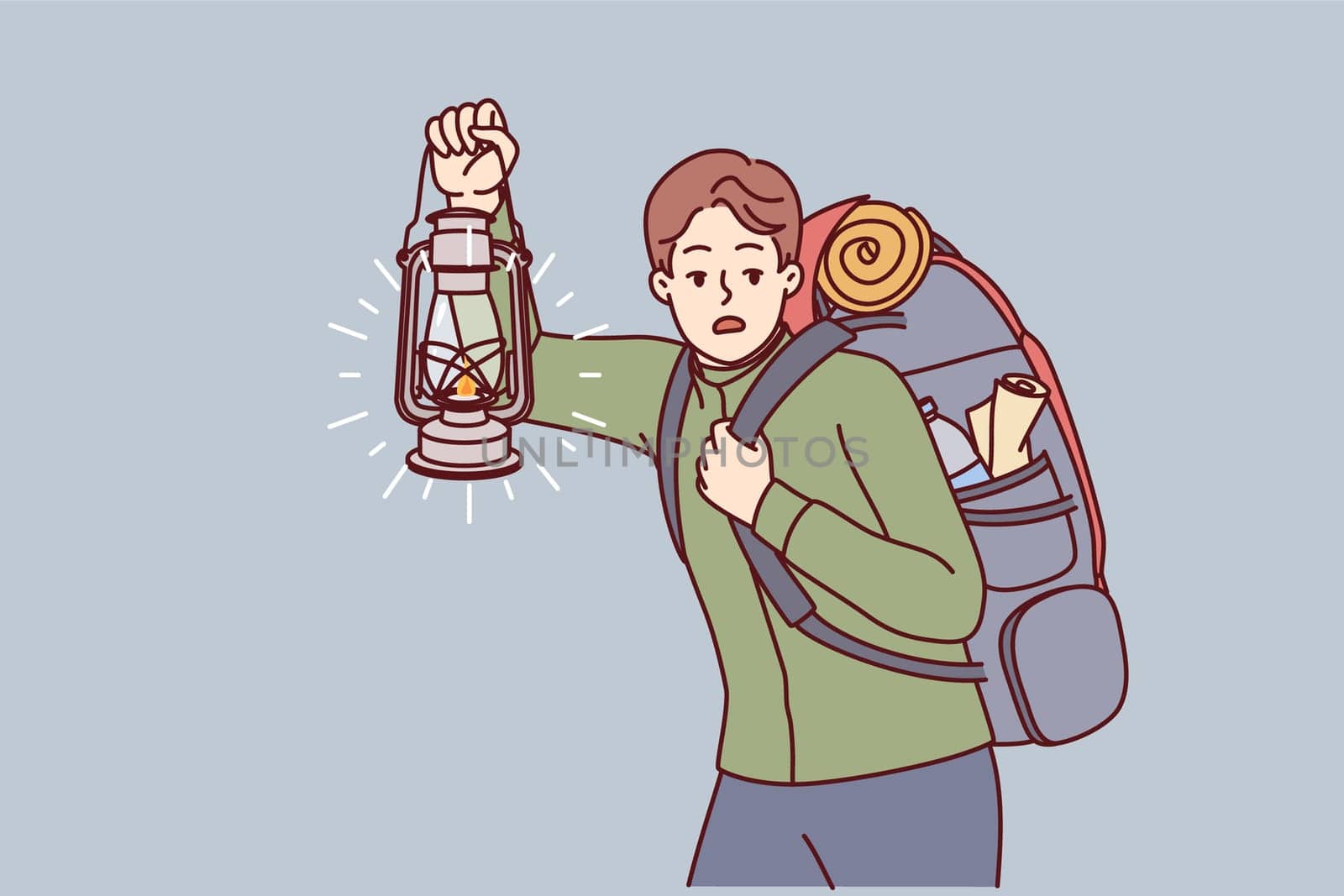 Man is engaged in hiking and carries large backpack on back, holding kerosene lantern to light way in dark. Frightened guy hears rustle in bushes and looks around while hiking in forest