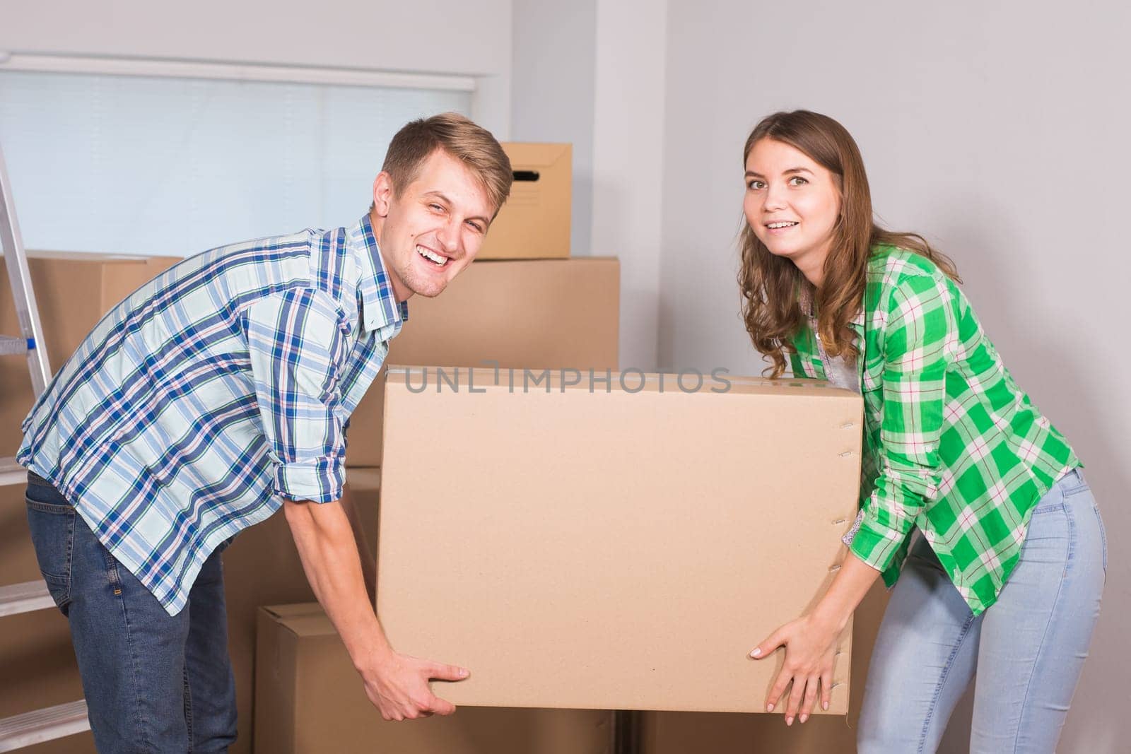 Happy young couple unpacking or packing boxes and moving into a new home