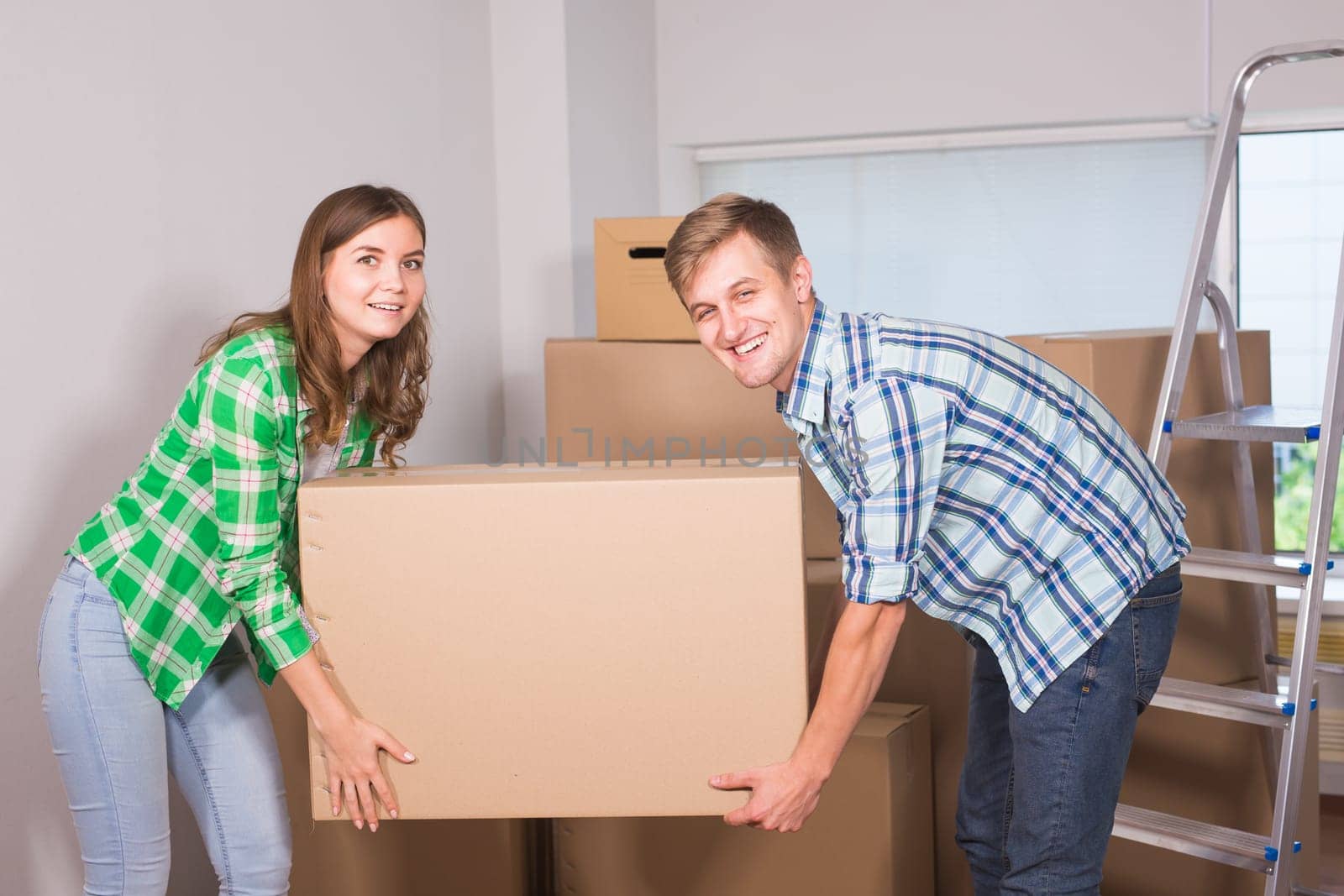 Happy young couple unpacking or packing boxes and moving into a new home