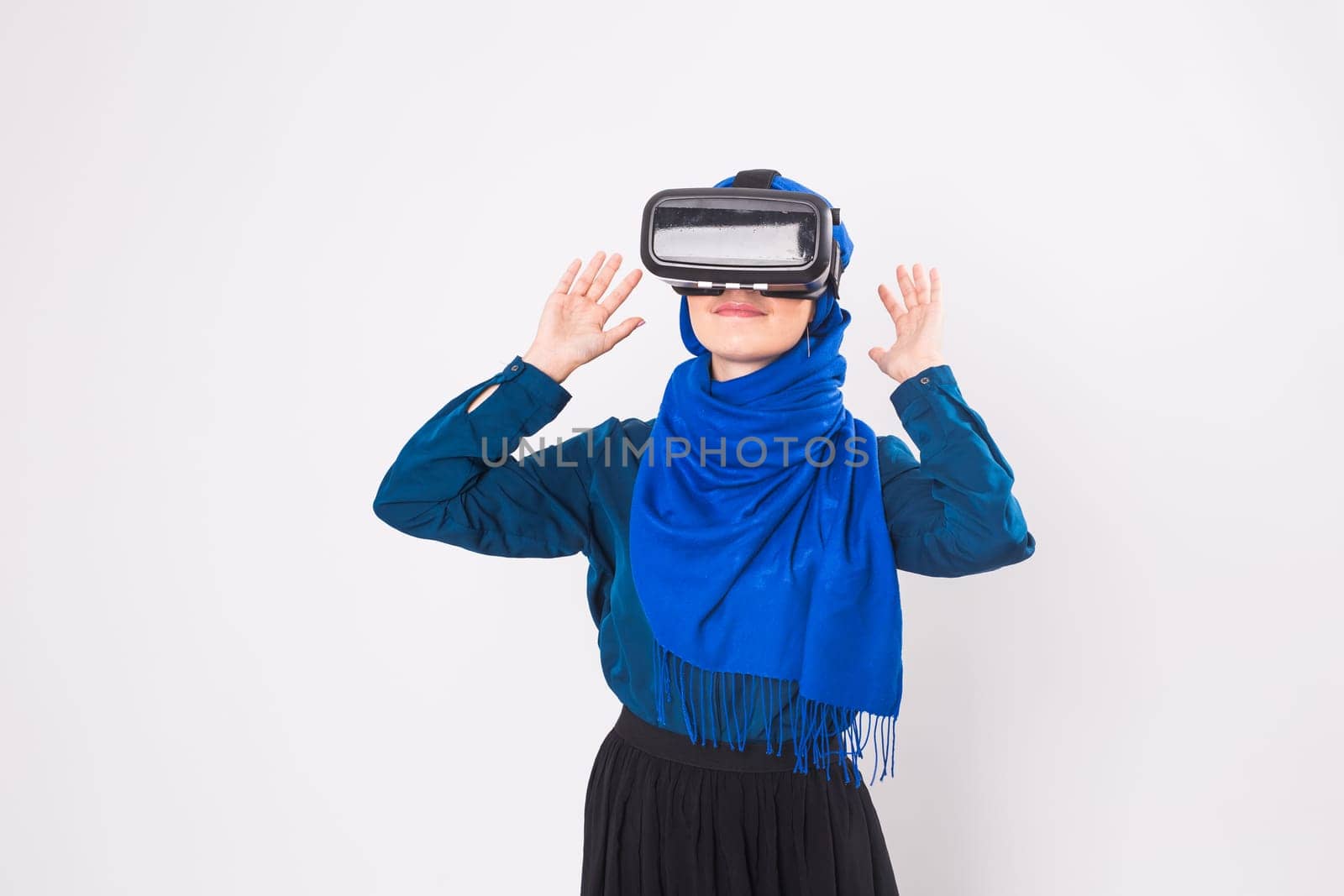 Asian muslim woman wearing hijab using VR headset glasses of virtual reality on white background
