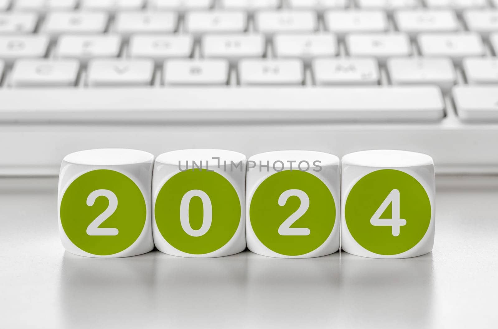 Letter dice in front of a keyboard - 2024