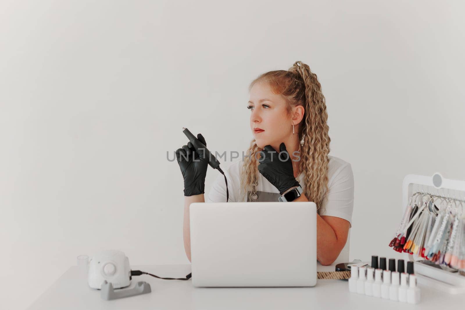 Woman Professional Manicurist at her Desk Works with a Laptop. Sign up for manicure Services, Freelancer Work Schedule