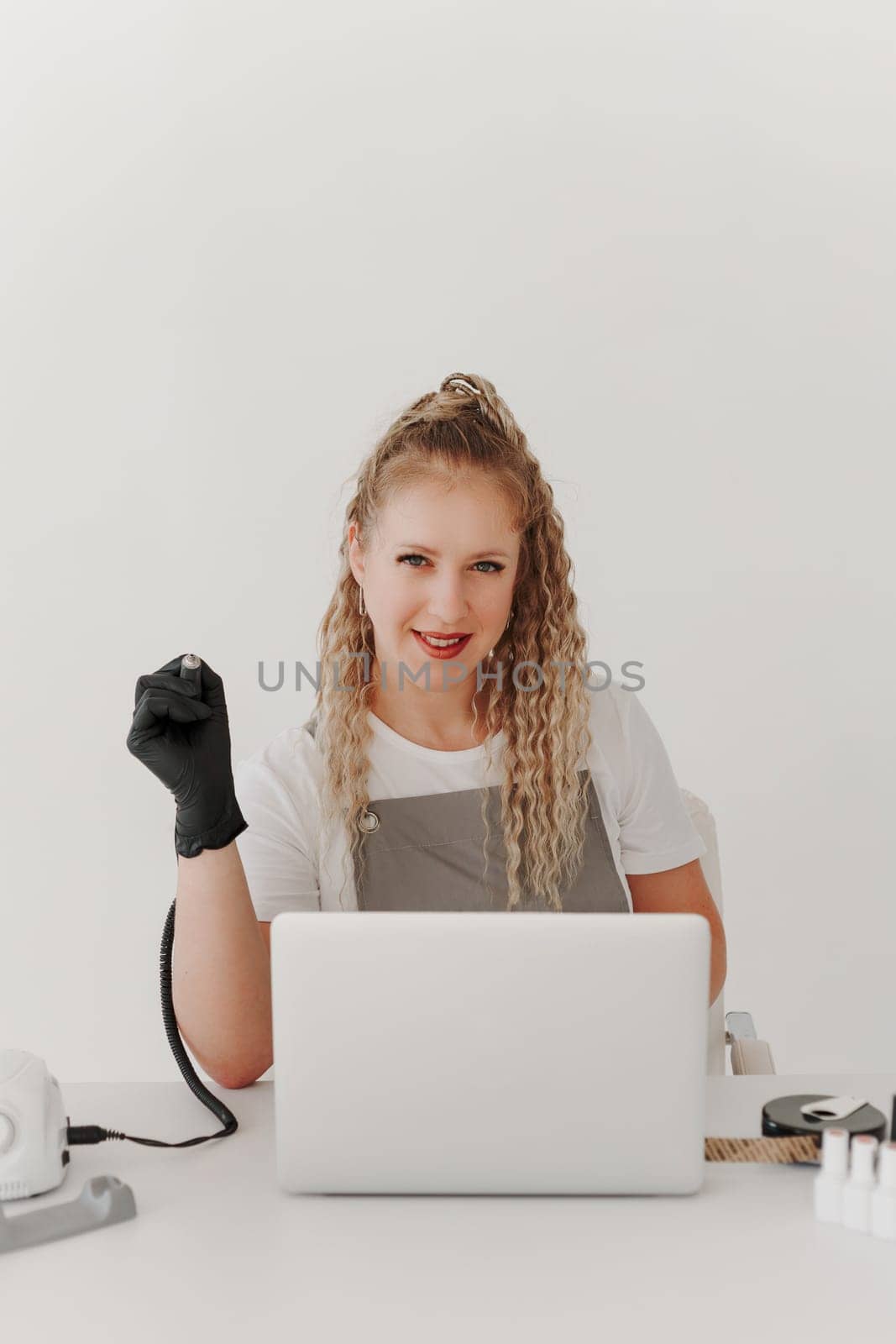 Woman Professional Manicurist at her Desk Works with a Laptop. Sign up for manicure Services, Freelancer Work Schedule.
