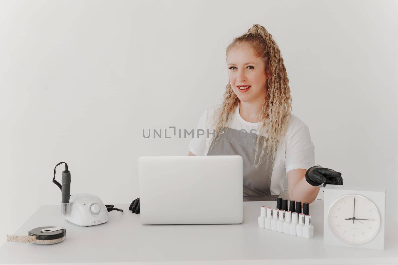 Woman Professional Manicurist at her Desk Works with a Laptop. Sign up for manicure Services, Freelancer Work Schedule