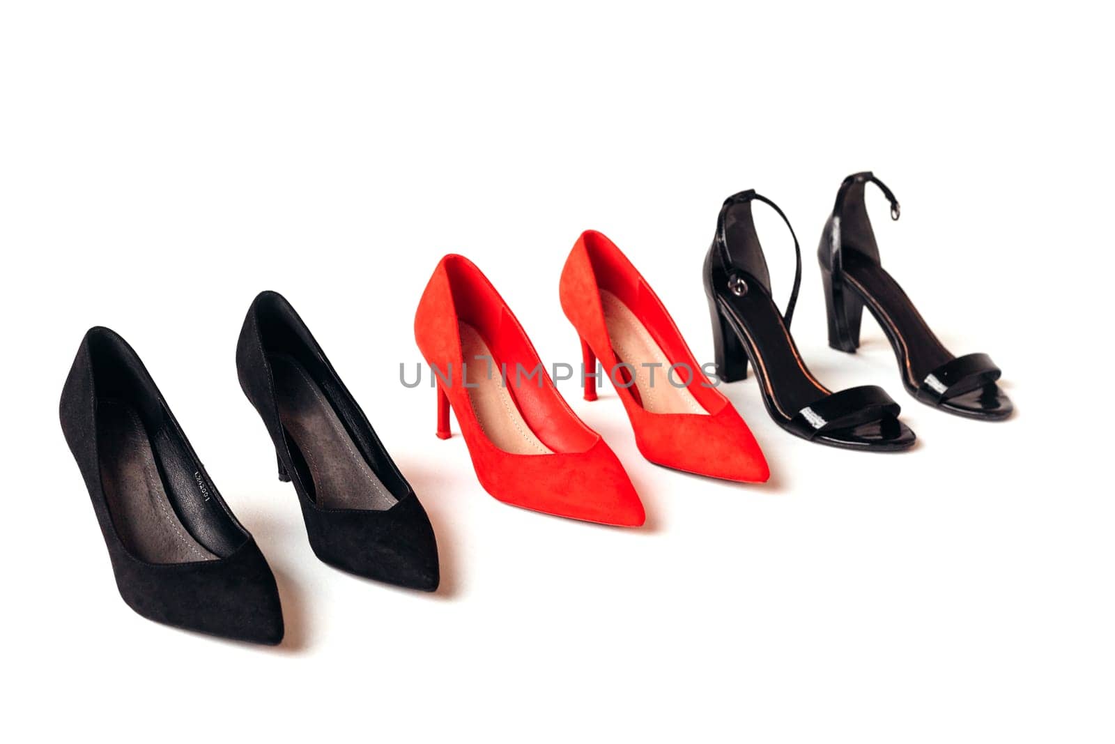 Red and black women's shoes with high heels on white background. Female classic stiletto heels in suede leather