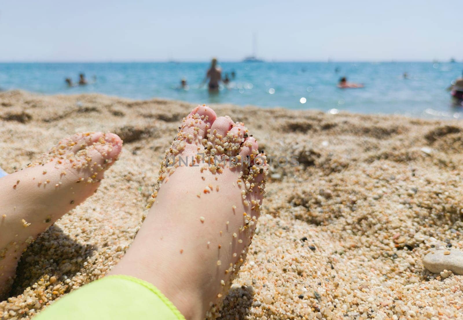 Childs feet covered in thick sand after bathing on the beach. Foot health for children