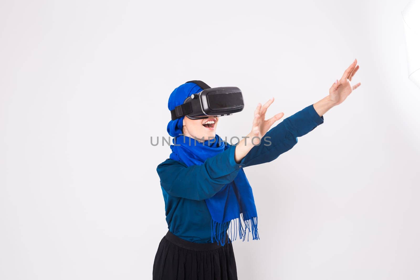 Asian muslim woman wearing hijab using VR headset glasses of virtual reality on white background
