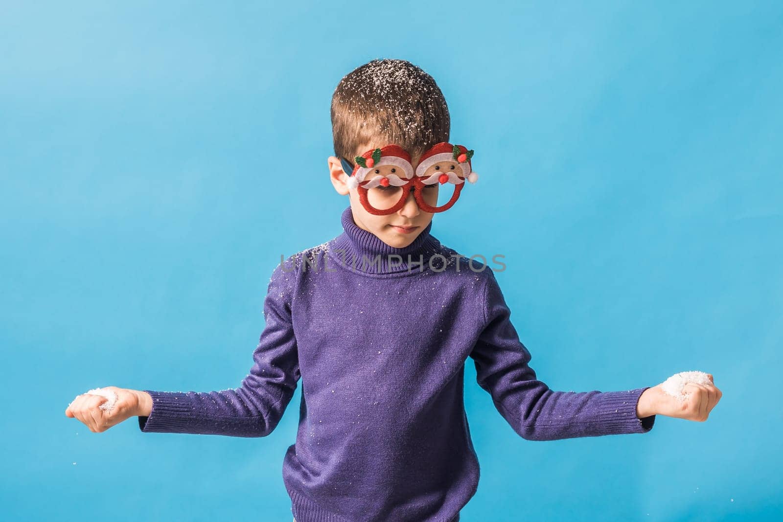 Child boy throws up on blue background. Christmas and New Year holidays concept. Generation alpha and gen alpha children. Copy space.