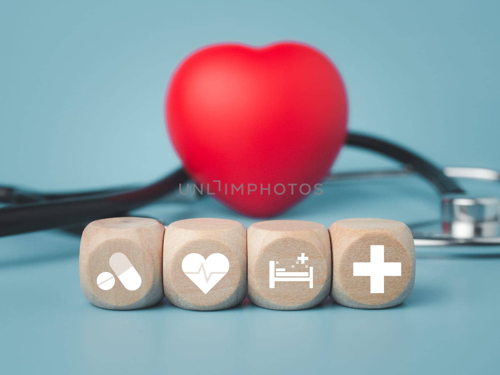 The concept of health insurance and medical welfare. Block wooden and red heart with plus icon. Health insurance and access to health care.