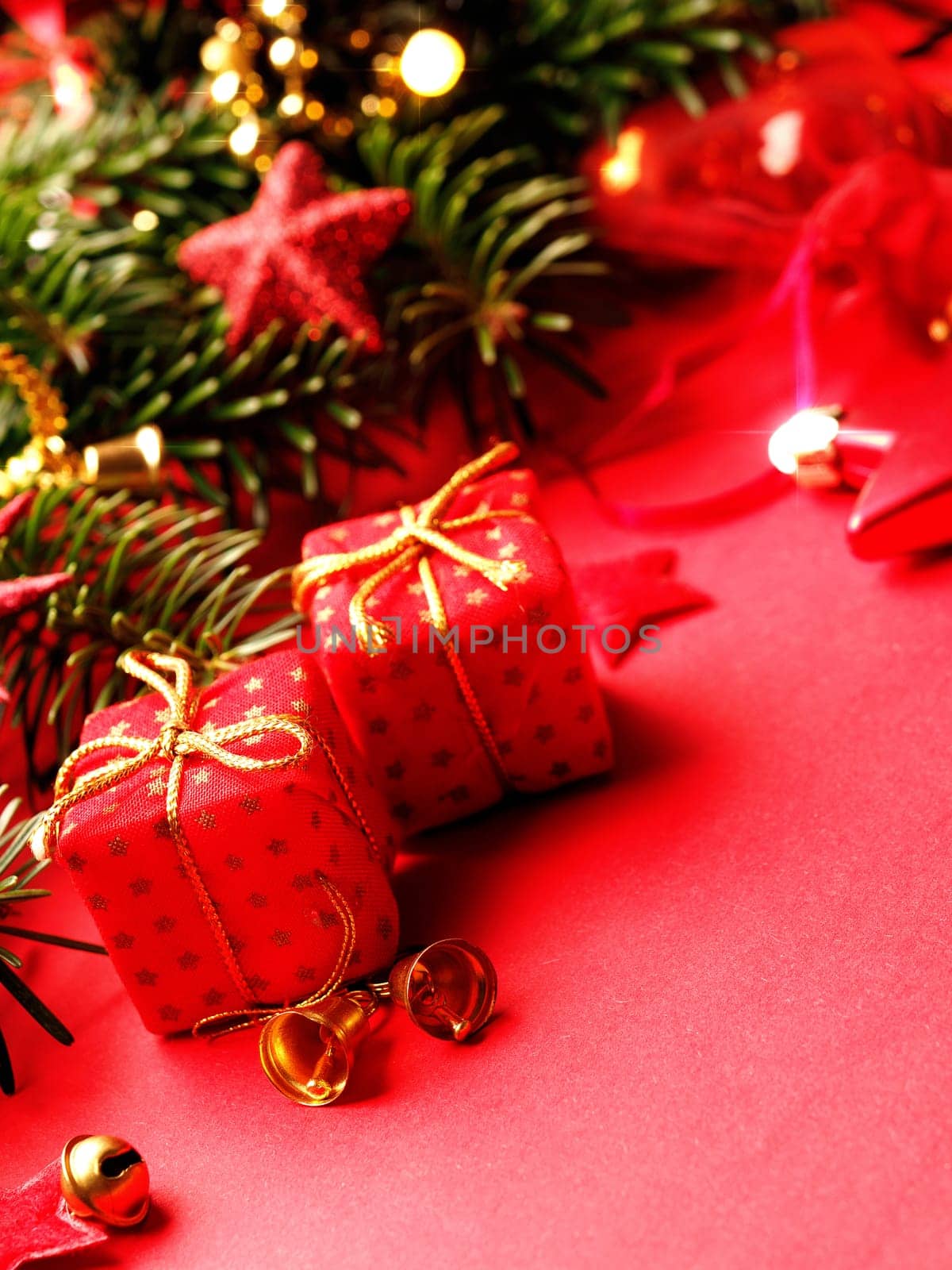 Traditional Christmas background with twigs of a fir tree and red Christmas decoration, selective focus on the foreground