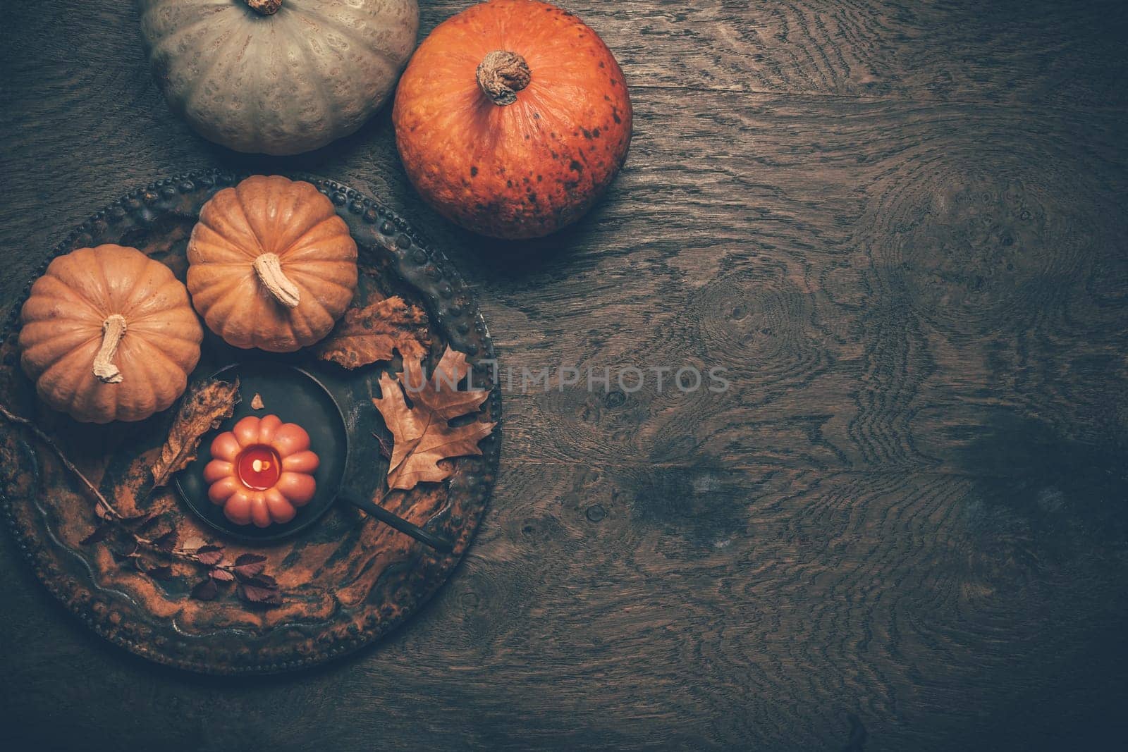 Autumn still life with pumpkins and candles on wooden background. Thankgsiving home decoration.