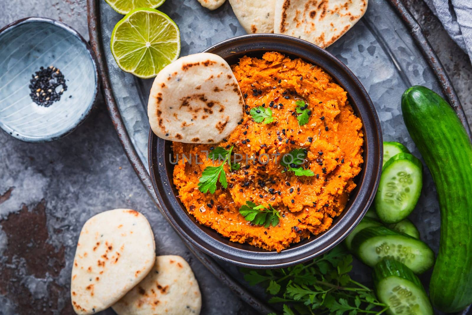 Homemade vegan Harissa carrot and lentil spread or dip with flatbread and cucumber