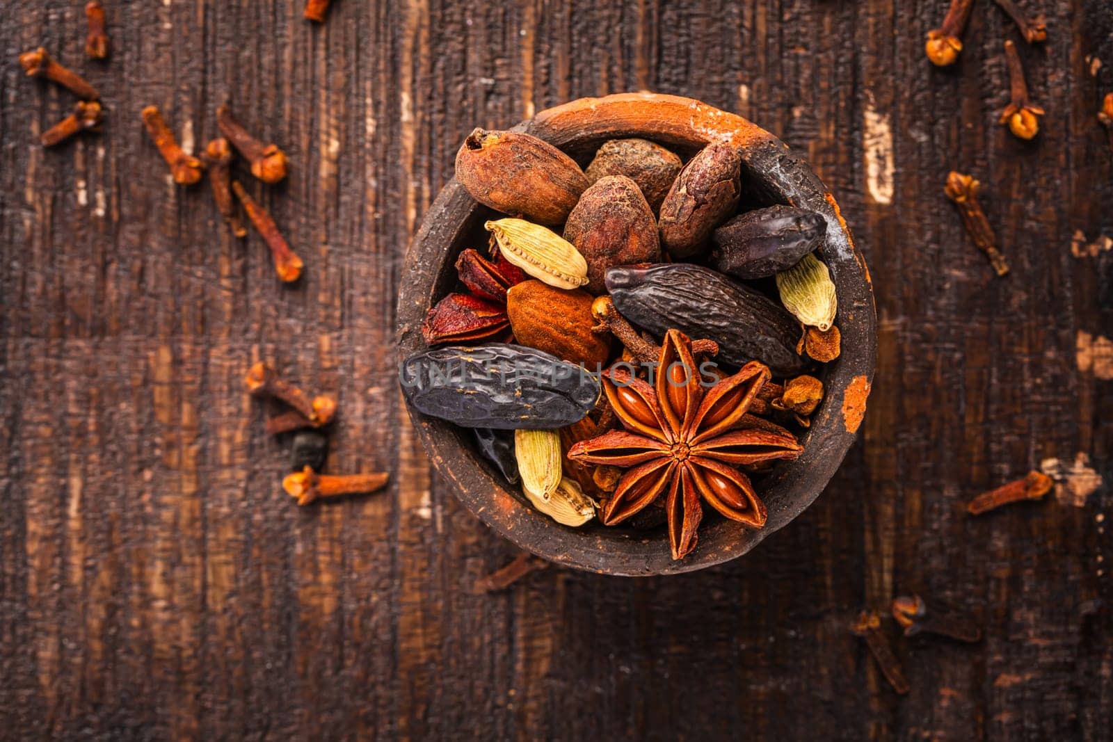 Christmas spices for baking cookies, Stollen or mulled wine in small bowl on wooden background.