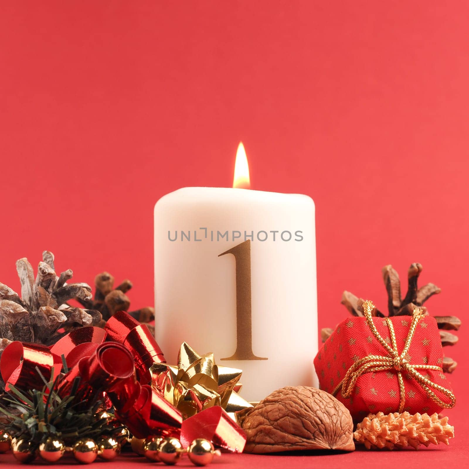 First Advent candle burns, white candle with the number one on a red background, Christmas decoration, space for text