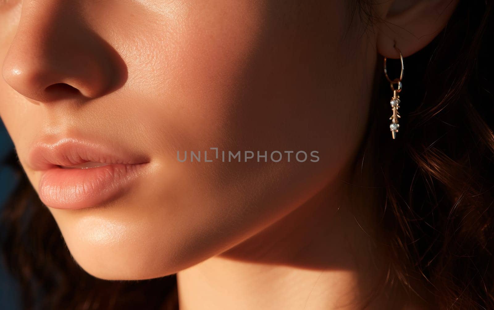 Beautiful woman with jewelry. A beauty shot of eerings on a dark background.