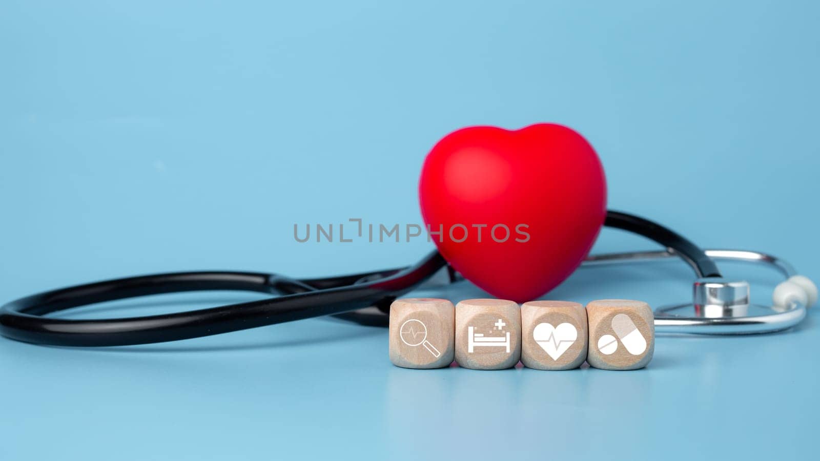 The concept of health insurance and medical welfare. Block wooden and red heart with plus icon. Health insurance and access to health care.