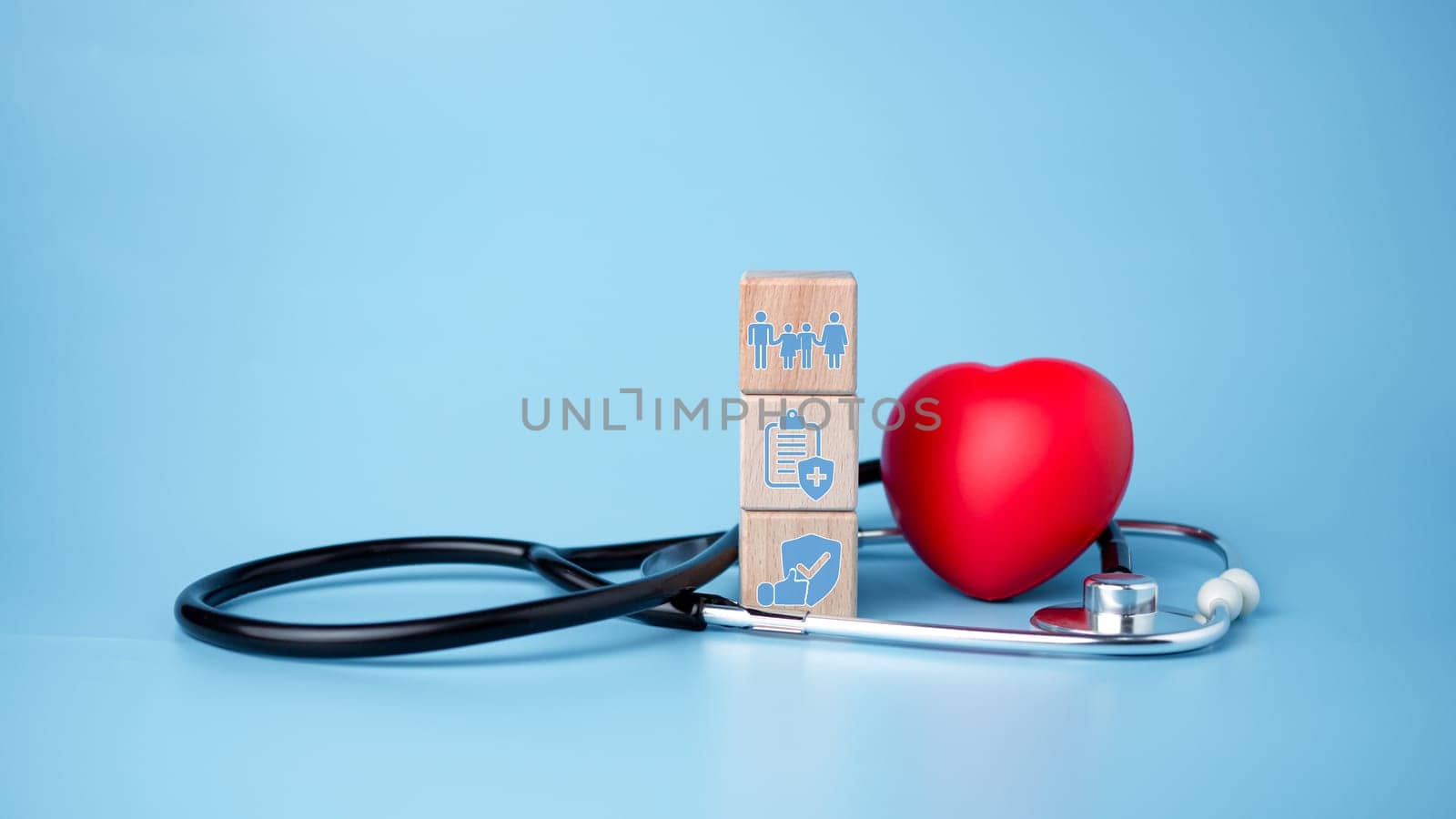 The concept of health insurance and medical welfare. Block wooden and red heart with plus icon. Health insurance and access to health care.