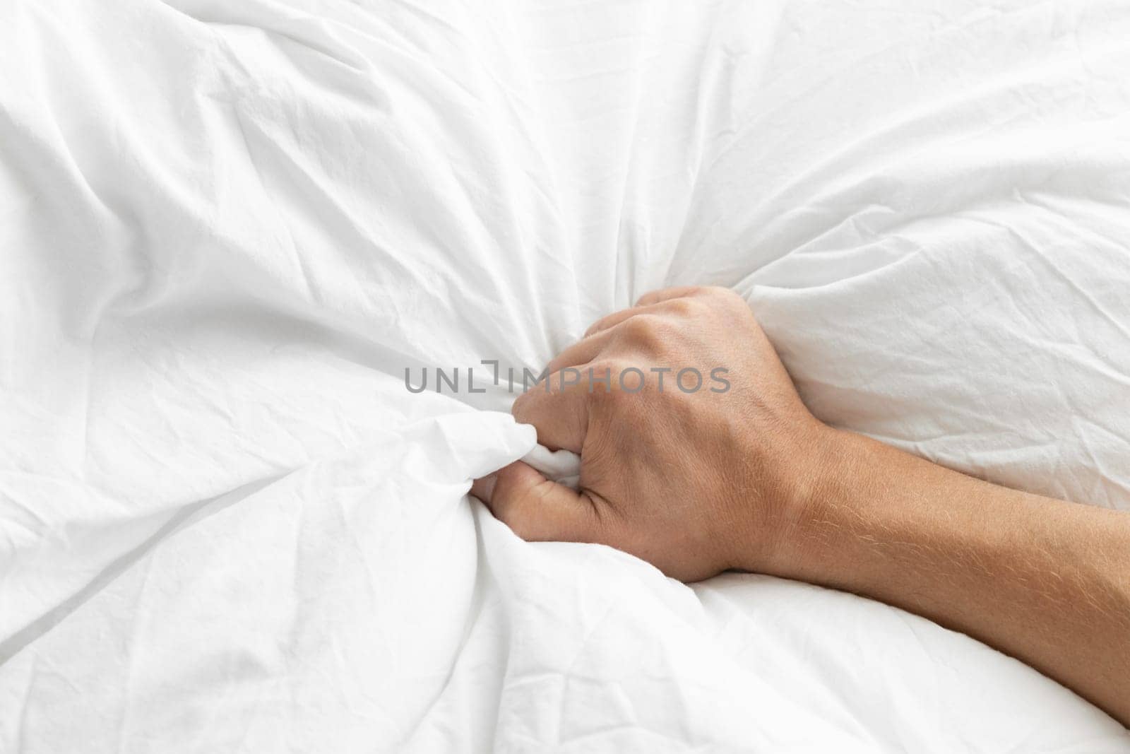 Man's hand squeezing a blanket, vintage white, soft focus. High quality photo