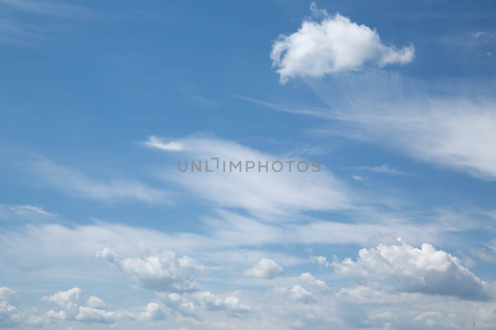 Panorama of white clouds in blue sunny bright sky in summer. High quality photo