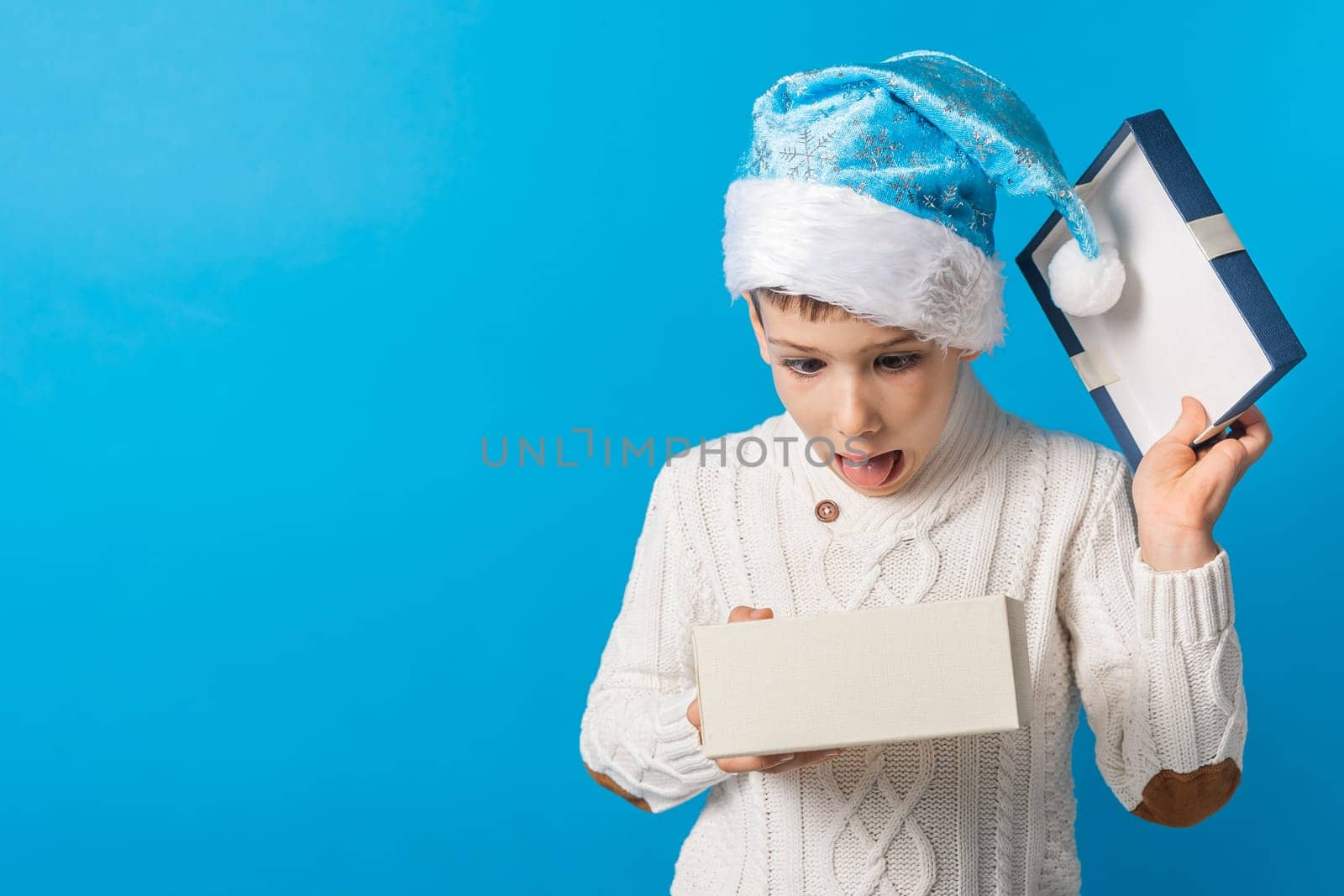 Child boy gift. Kid in blue christmas hat holds gift box. Shopping time. Banner header with copy space. Generation alpha and gen alpha