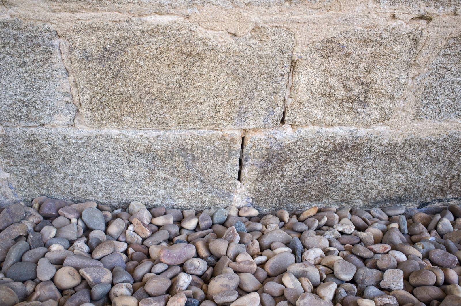 Granite ashlars wall with river pebble stones as ground. Flooring techiques for drainage