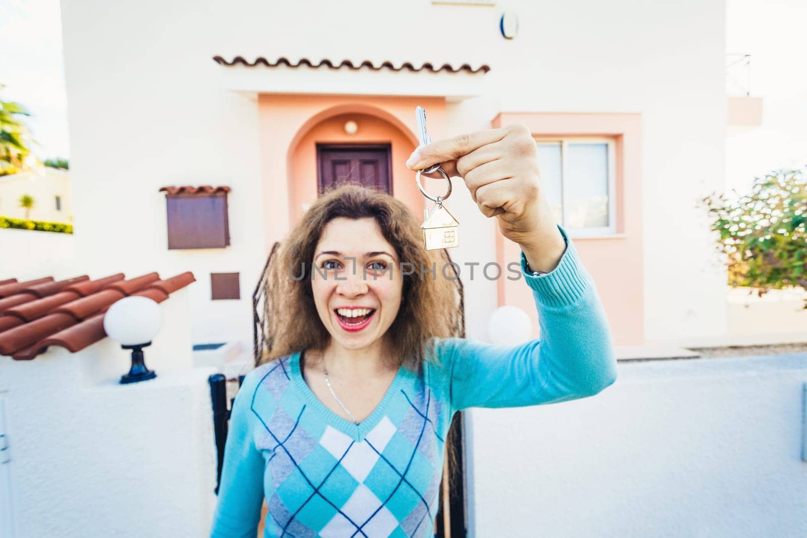 Woman With Keys Standing Outside New Home.