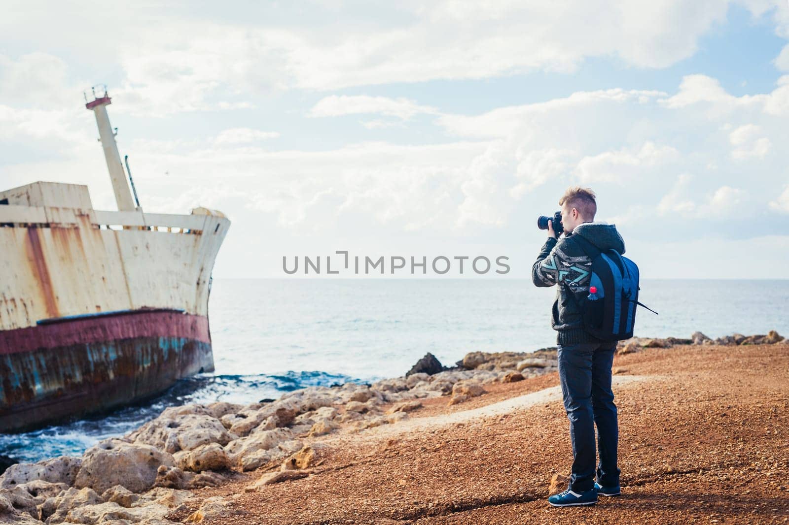 Young handsome male photographer on the beach