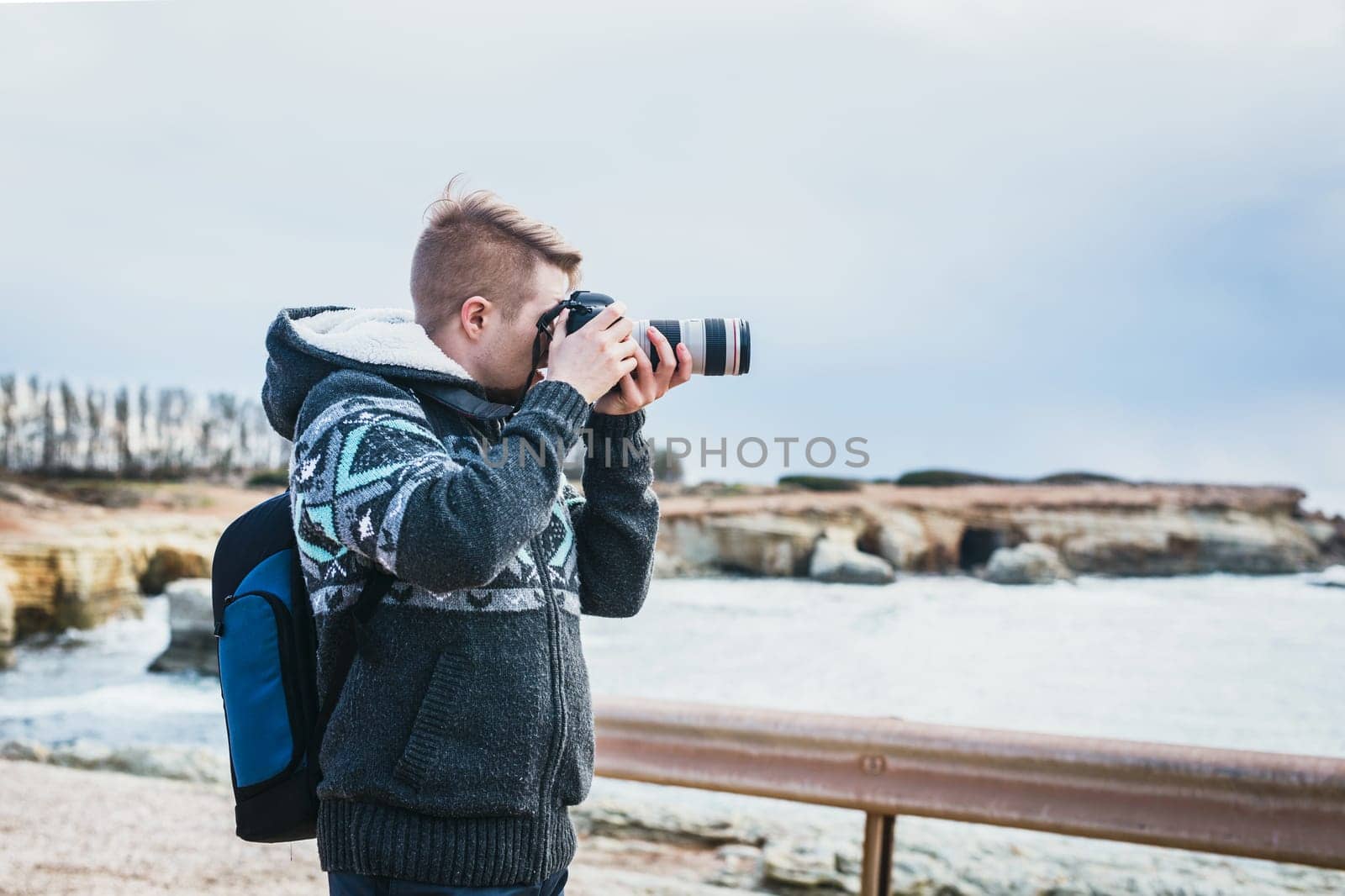 Young handsome male photographer on the beach